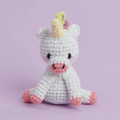 Crocheted unicorn toy on a light purple background