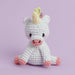 Crocheted unicorn toy on a light purple background