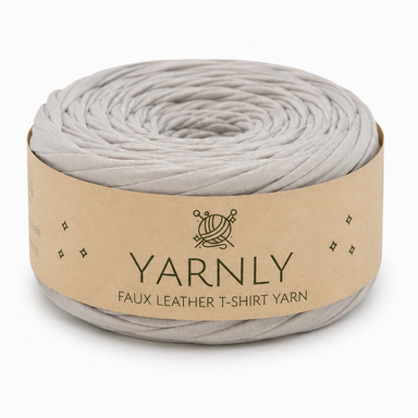 A roll of Yarnly faux leather T-shirt yarn in a light gray color, wrapped in a kraft paper band with the brand name 'YARNLY' printed on it, set against a plain white background.