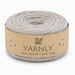 A roll of Yarnly faux leather T-shirt yarn in a light gray color, wrapped in a kraft paper band with the brand name 'YARNLY' printed on it, set against a plain white background.