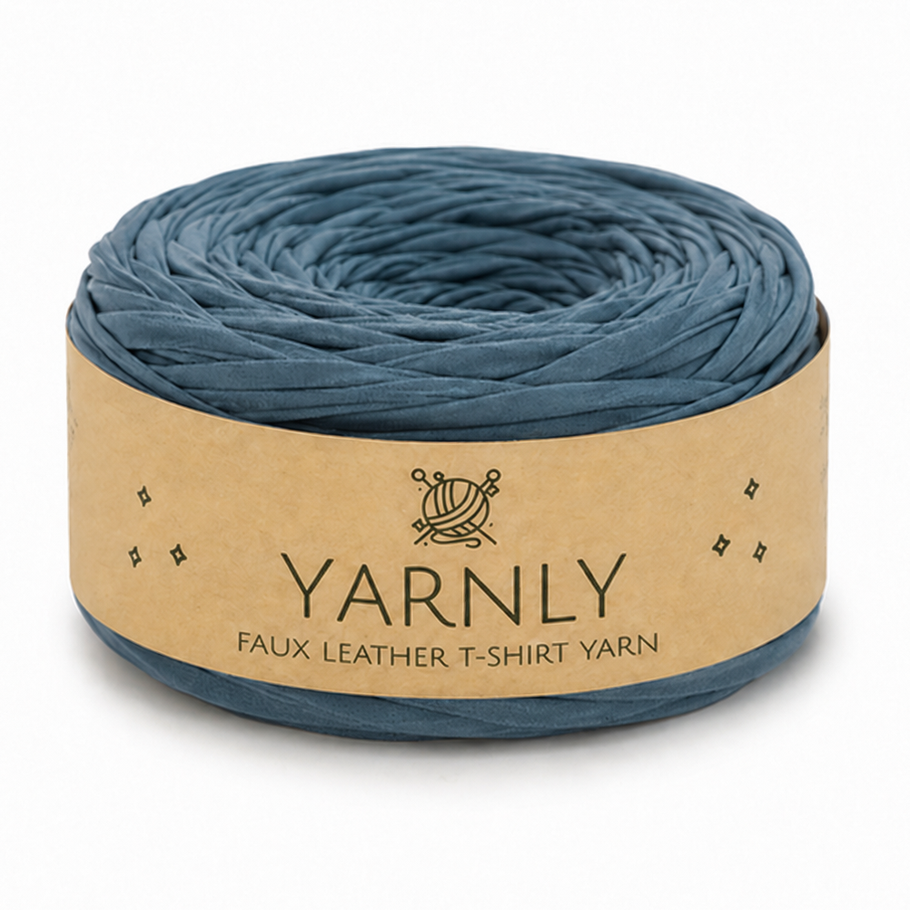A roll of Yarnly faux leather t-shirt yarn in a muted slate blue color, wrapped in a kraft paper band with the brand name clearly visible.