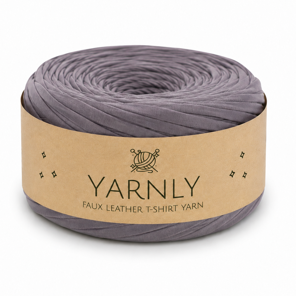 A roll of Yarnly faux leather t-shirt yarn in a muted grayish purple color, wrapped in a kraft paper band with the brand name 'YARNLY' printed on it, set against a plain white background.