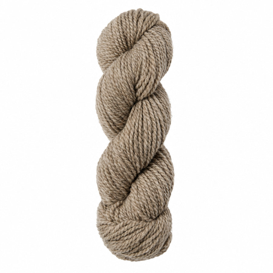 Coiled skein of beige yarn on a white background