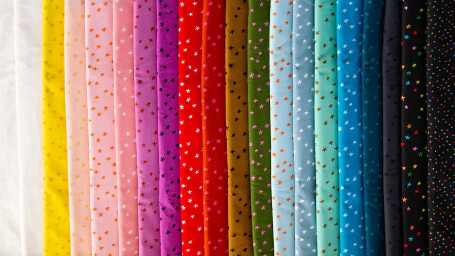 Row of colorful fabric swatches on a textured surface