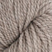 A skein of thick, twisted wool yarn in a warm taupe-gray color, photographed vertically against a textured white fabric background.